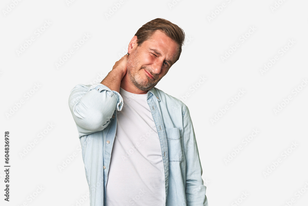 A middle-aged man isolated having a neck pain due to stress, massaging and touching it with hand. A middle-aged man isolated having a neck pain due to stress, massaging and touching it with hand.