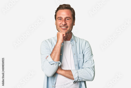 A middle-aged man isolated smiling happy and confident, touching chin with hand. © Asier