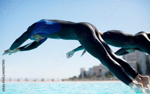 Triathletes diving into swimming pool