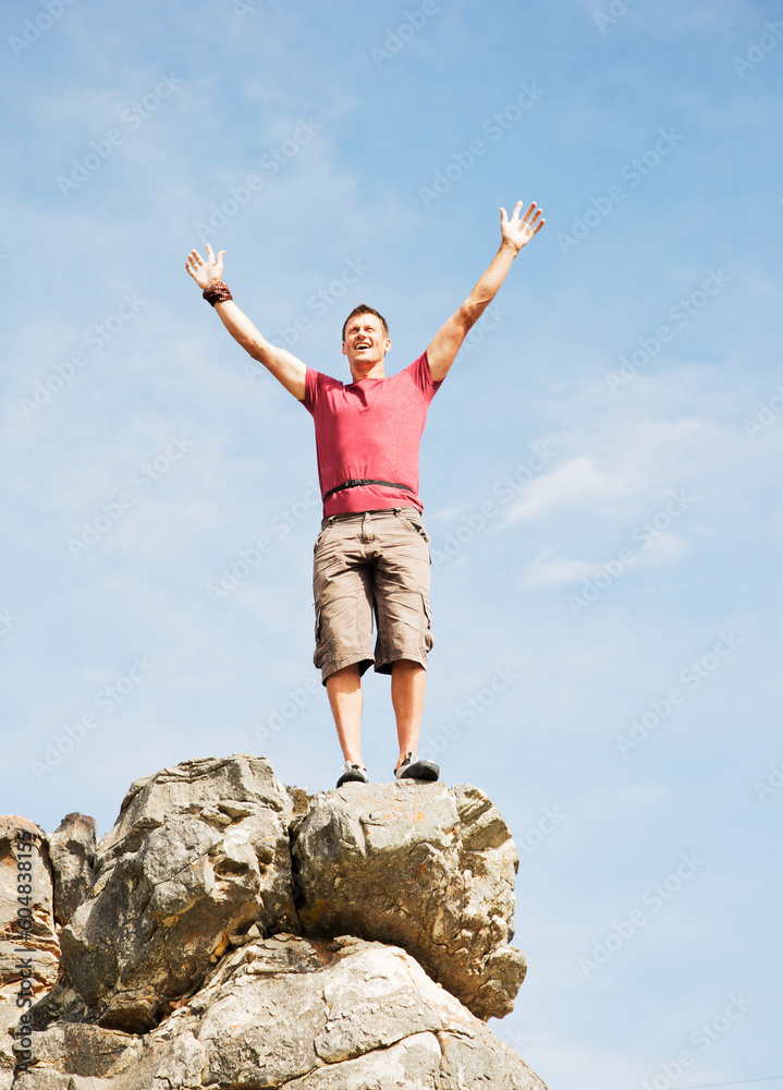 Climber cheering on rocky hilltop Climber cheering on rocky hilltop