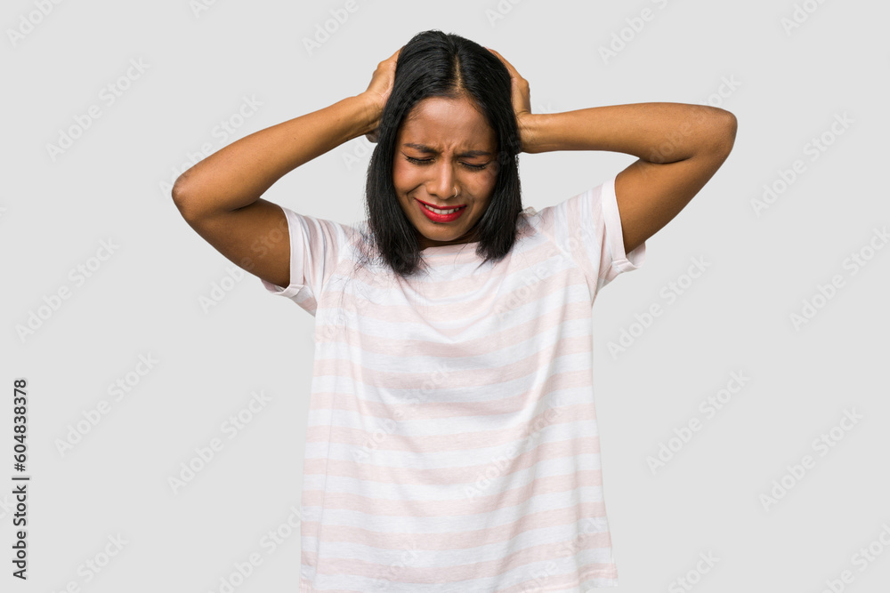 Young Indian woman cut out isolated on white background covering ears with hands trying not to hear too loud sound. Young Indian woman cut out isolated on white background covering ears with hands trying not to hear too loud sound.