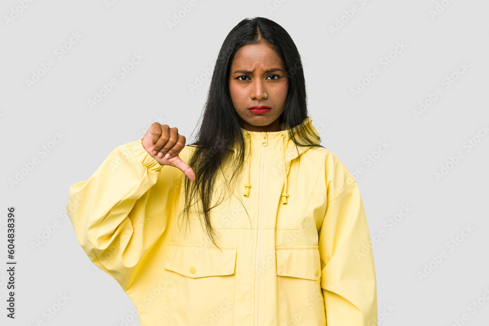 Young Indian woman cut out isolated on white background showing a dislike gesture, thumbs down. Disagreement concept. Young Indian woman cut out isolated on white background showing a dislike gesture, thumbs down. Disagreement concept.