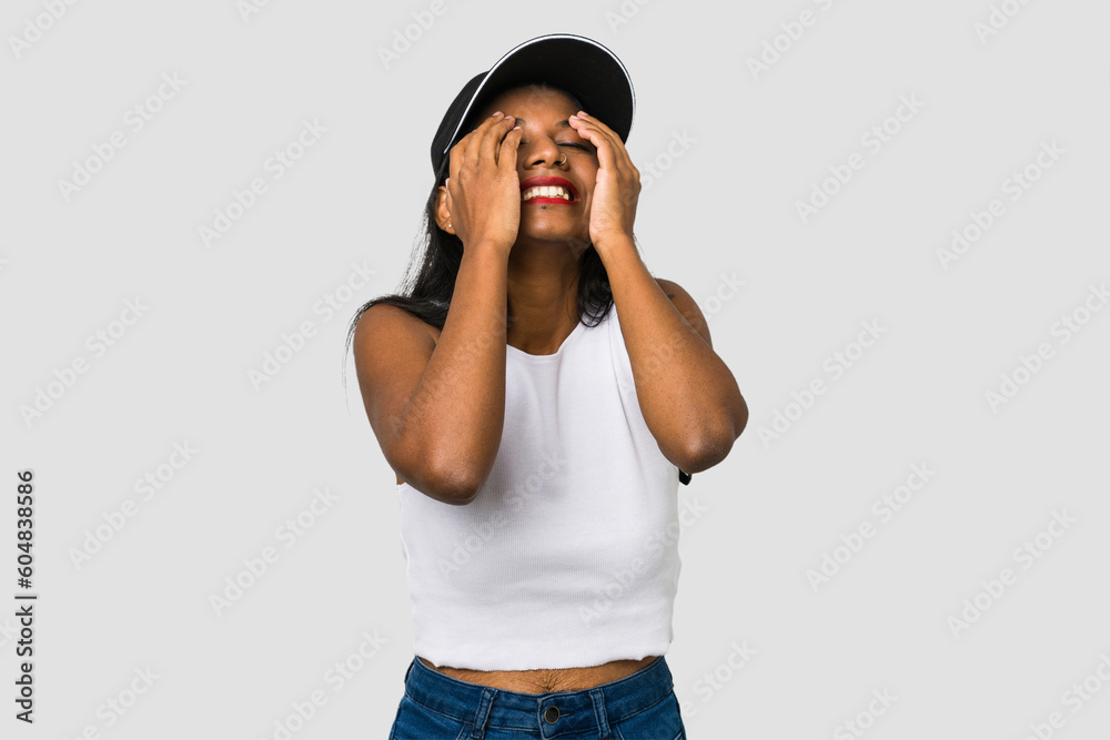 Young Indian woman cut out isolated on white background laughs joyfully keeping hands on head. Happiness concept. Young Indian woman cut out isolated on white background laughs joyfully keeping hands on head. Happiness concept.