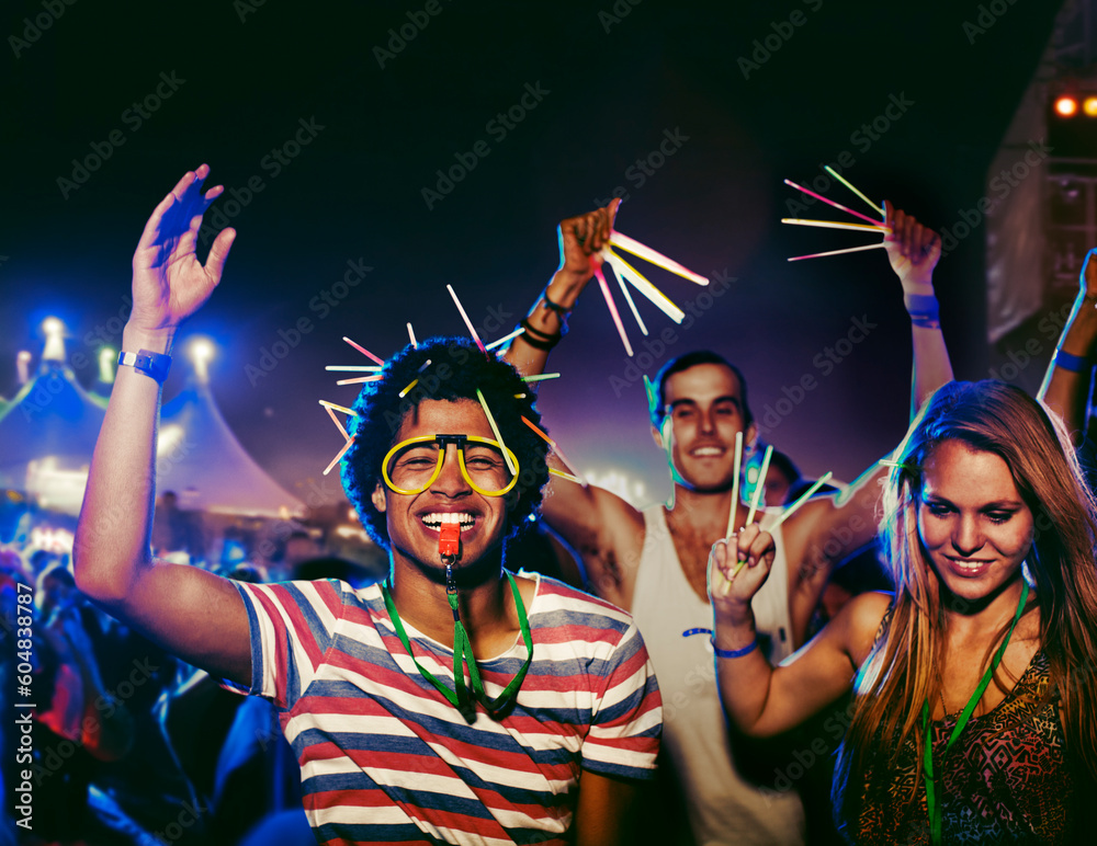 Fans with glow sticks cheering at music festival - obrazy, fototapety, plakaty 