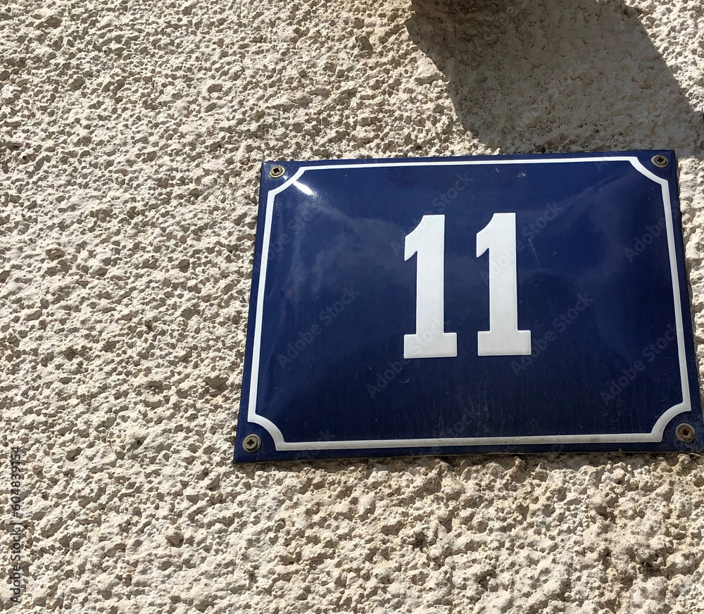 Shiny blue metal plate that says 11 Shiny blue metal plate that says 11