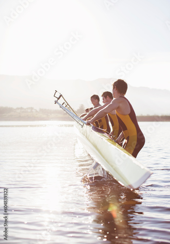 Rowing team placing boat in lake