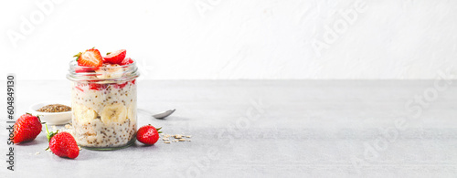 Photos Overnight Oats with Fresh Strawberry, Banana and Chia Seeds in Jars on Light Gre