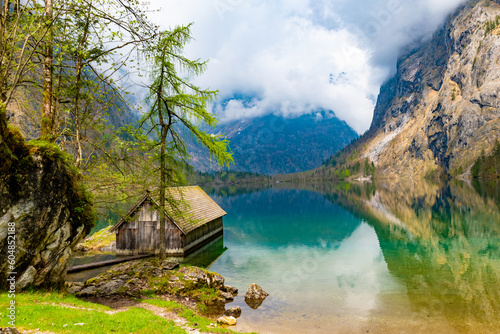 Foto Lonely boathouse on Obersee surrounded by mighty mountains shrouded in mythical