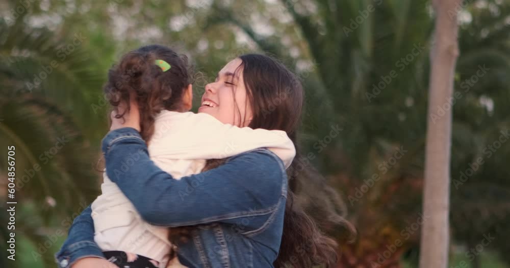 The little girl runs with excitement towards her sister and they share a loving embrace. You can see joy and happiness radiating from their faces The little girl runs with excitement towards her sister and they share a loving embrace. You can see joy and happiness radiating from their faces