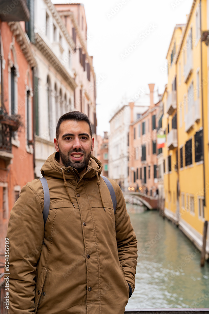 Young male tourist on the canals of Venice happily