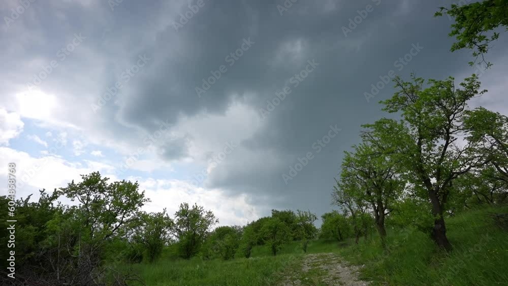 Storm clouds time lapse. 4k video with storm cloud sky moving fast over a forest landscape with green trees. Storm clouds time lapse. 4k video with storm cloud sky moving fast over a forest landscape with green trees.