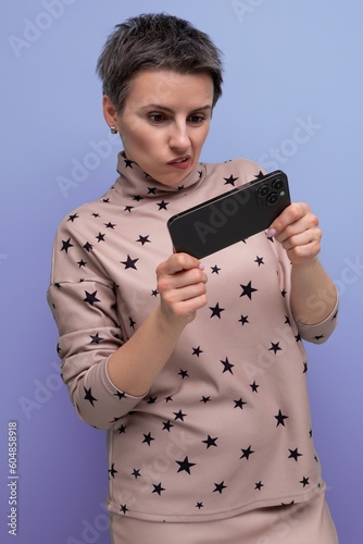 young pretty caucasian woman with short gray hair dressed in a suit of a skirt and blouse is playing on the phone