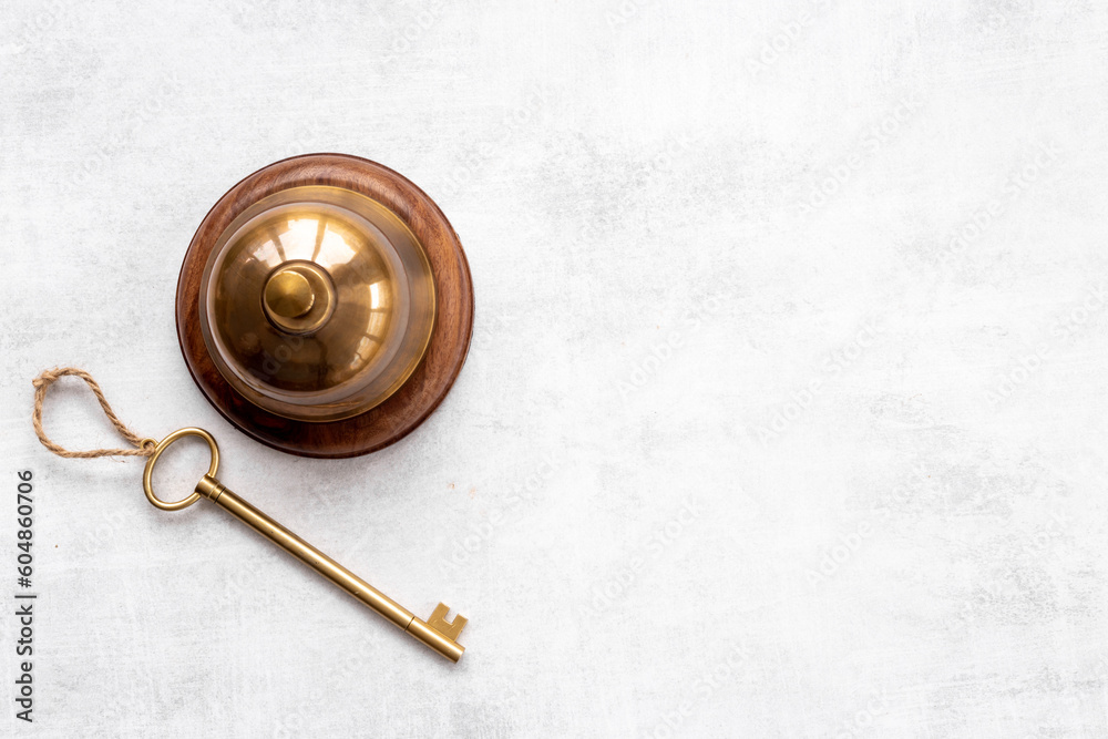 Golden hotel service bell with key on reception desk Golden hotel service bell with key on reception desk