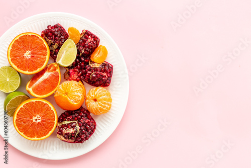 Layout of citrus fruits on white plate top view