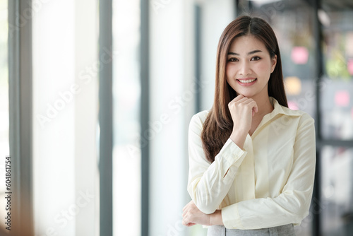 Charming Asian woman with a smile looking to the camera in the office.