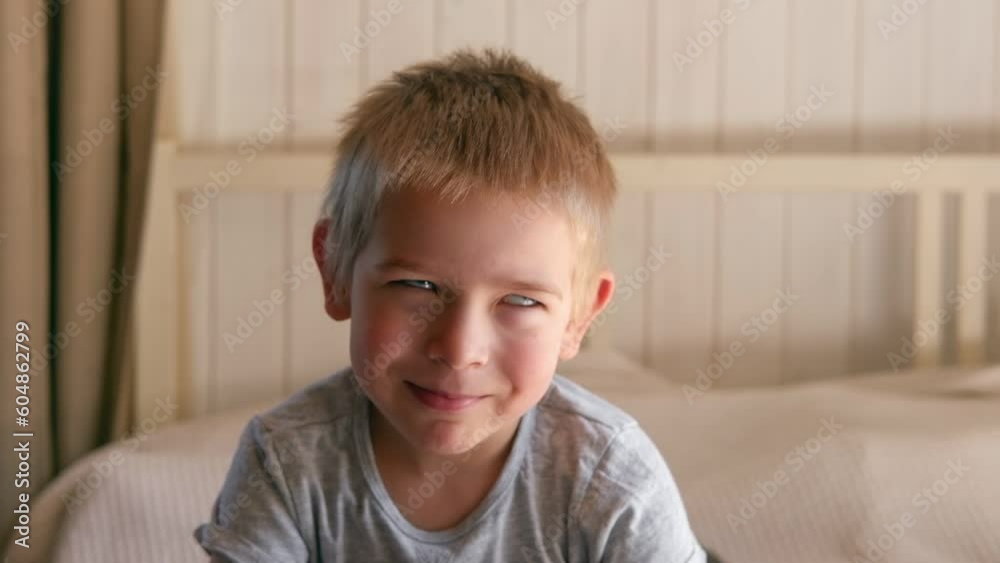 Boy joking, sticking tongue out with silly expression. Child making face. Funny foolishness portrait of little baby boy on the bedroom background. Adorable caucasian kid making crazy comical gesture Boy joking, sticking tongue out with silly expression. Child making face. Funny foolishness portrait of little baby boy on the bedroom background. Adorable caucasian kid making crazy comical gesture