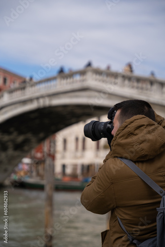 young male tourist photographing the canals of venice