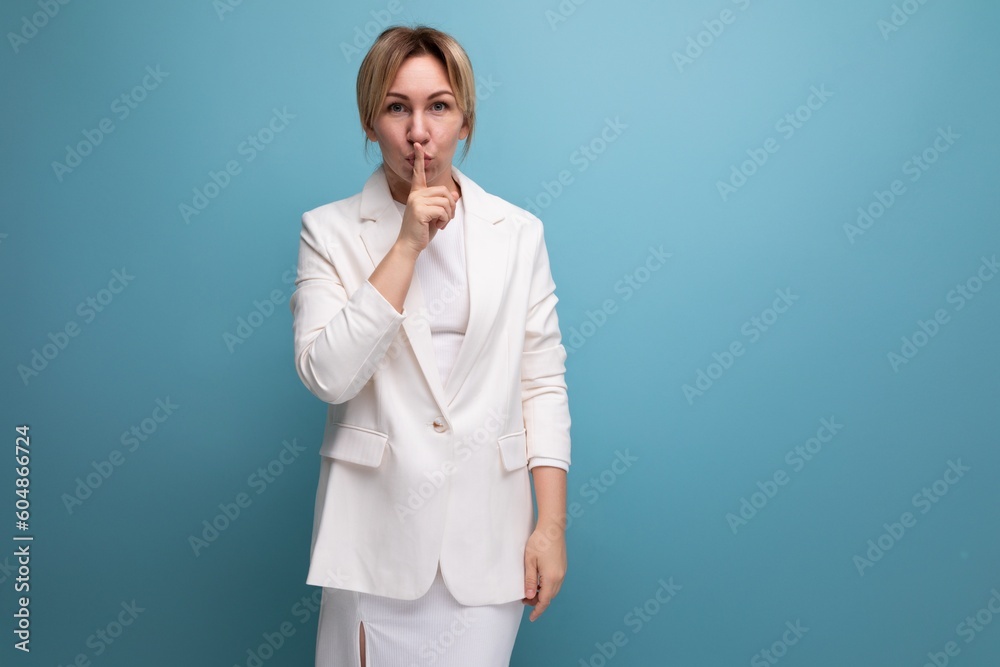 smart successful young blond career woman in white elegant jacket and skirt communicates idea on blue background with copy space smart successful young blond career woman in white elegant jacket and skirt communicates idea on blue background with copy space