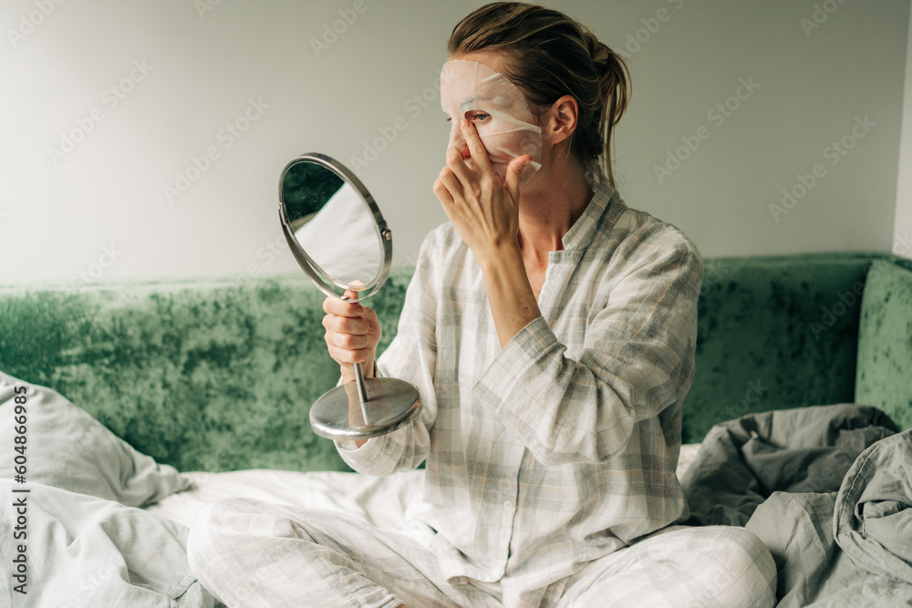 A woman makes a caring beauty procedure at home, a moisturizing cosmetic face mask.