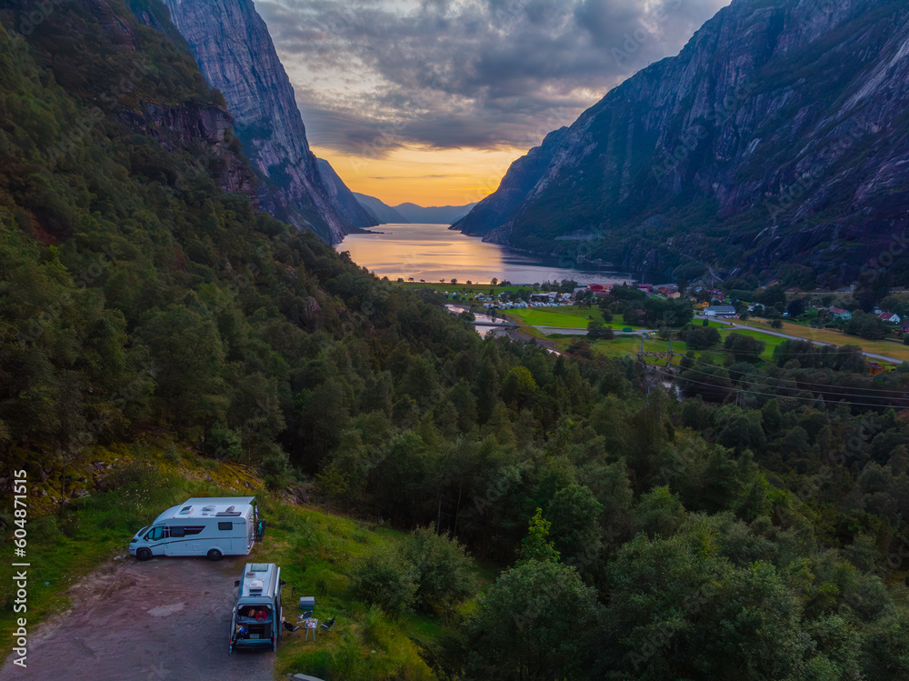 sunset by a fjord with beautiful views of the Norwegian mountains, travel with van, photo taken with drone. Vacation concept