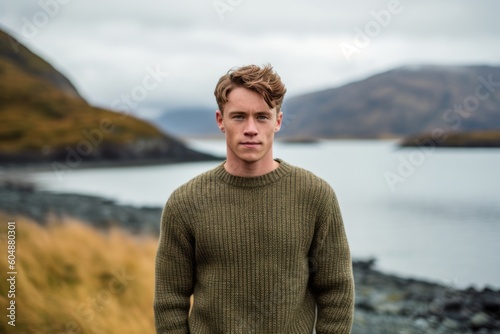 Medium shot portrait photography of a glad boy in his 30s wearing a cozy sweater against a scenic lagoon background. With generative AI technology