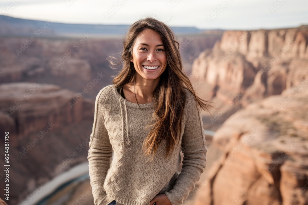 Lifestyle portrait photography of a grinning girl in her 30s wearing a cozy sweater against a scenic canyon background. With generative AI technology Lifestyle portrait photography of a grinning girl in her 30s wearing a cozy sweater against a scenic canyon background. With generative AI technology