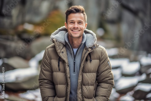Lifestyle portrait photography of a happy boy in his 30s wearing a cozy winter coat against a serene rock garden background. With generative AI technology © Markus Schröder
