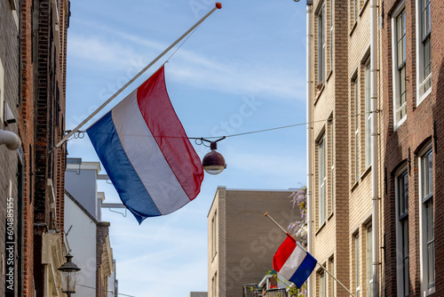 Remembrance of the Dead (Nationale Dodenherdenking) On 04 May every year, National flag of the Netherlands with half-mast, Memorial to victims of the world war two, Dutch flag hanging outside building photo