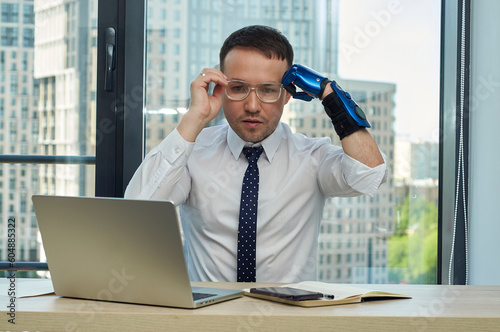 Man with Hand Prosthesis Working in an Office: Computer and Phone, documents