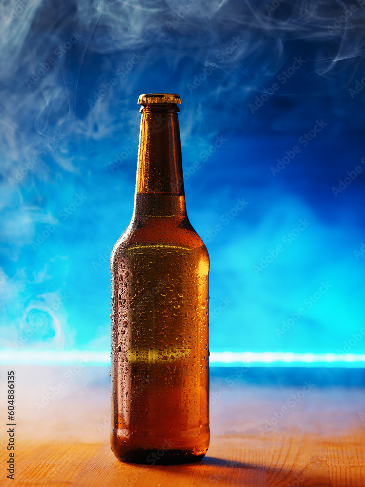 cold bottle of beer with water drops on a blue background cold bottle of beer with water drops on a blue background