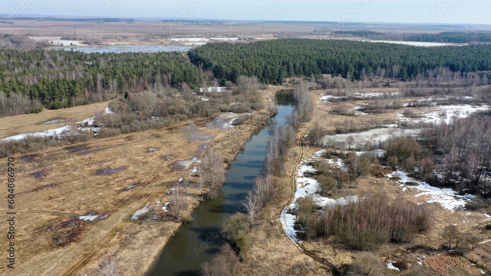 aerial photography of a fast river, a top view of the river and a meadow with a forest. awakening of nature