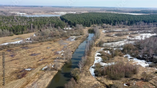 aerial photography of a fast river, a top view of the river and a meadow with a forest. awakening of nature