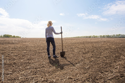 Woman farmer stands on his parched meadow.  farmer at drought field. drought season.