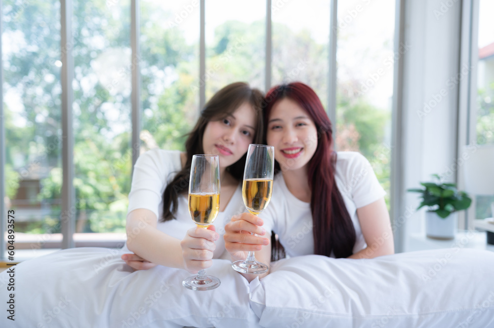 The LGBT couple celebrating with a glass of wine In a hotel room surrounded by nature The LGBT couple celebrating with a glass of wine In a hotel room surrounded by nature