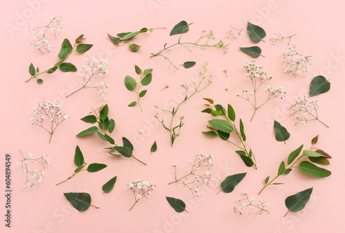 Top view image of flowers composition over pink pastel background