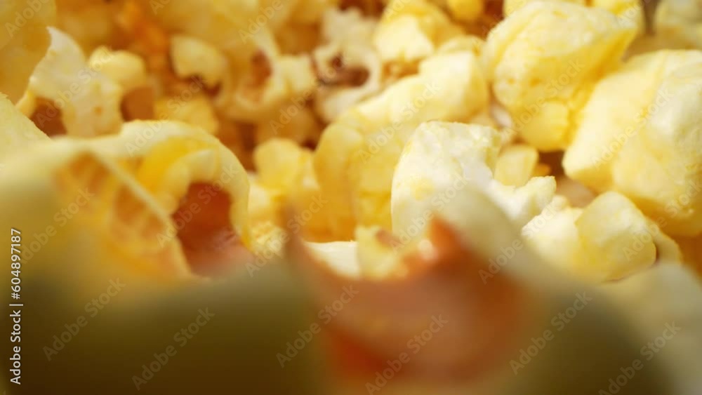 In a macro video captured with a probe lens, the scattered popcorn on the floor comes to life. showcasing its unique shape, texture, and golden hues. Crumbs and remnants create an intricate mosaic. 4K