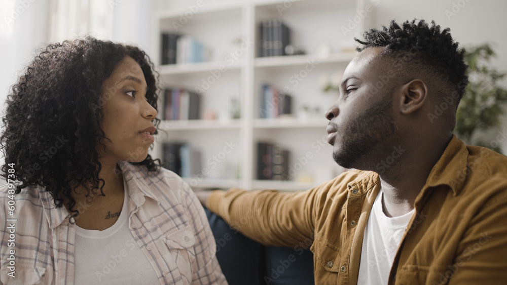 Beautiful African American couple having conversation at home, showing love and appreciation Beautiful African American couple having conversation at home, showing love and appreciation