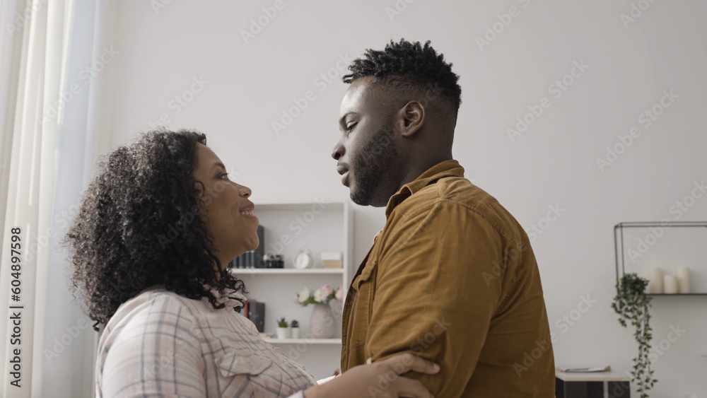 © Synthex - Happy African American couple hugs as the woman tells her husband that she is pregnant