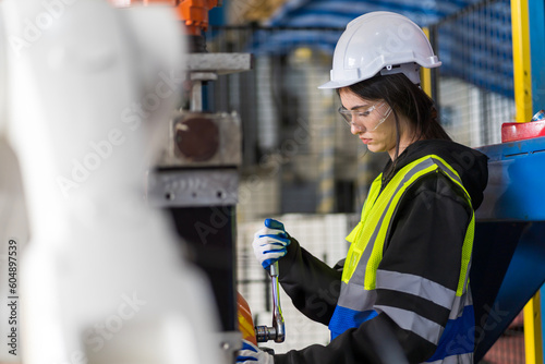 A team of female engineers meeting to inspect computer-controlled steel welding robots. Plan for rehearsals and installation for use.