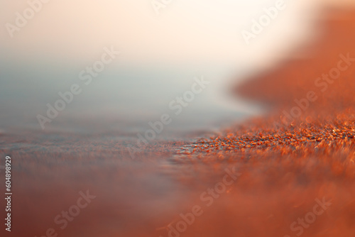 Shimmering Treasures: Serene Baltic Sea Shoreline. Shallow deapth of field picture of sandy Baltic Sea shores during sunrise. Northern Europe scenery photo