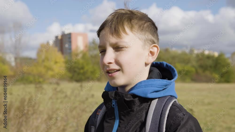 A cute young boy talks to someone off camera and points at something on a field - closeup A cute young boy talks to someone off camera and points at something on a field - closeup