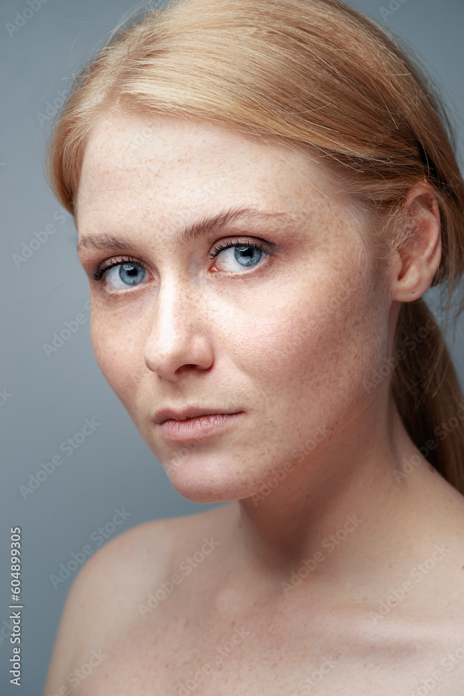 Natural beauty. Blonde woman with healthy skin.  No makeup. Grey background.