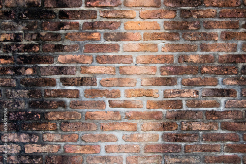 Grunge old and crack red color brick with black stain wall textured background.