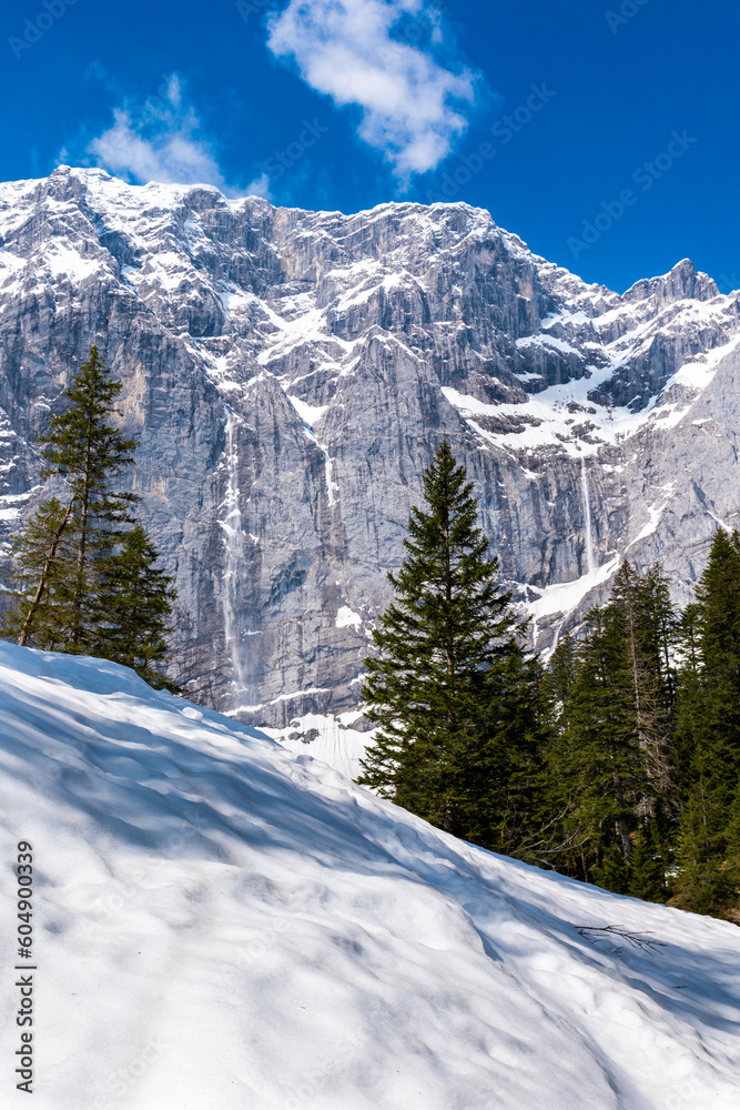 View of the rock wall in Enger Grund amidst snowy alpine landscape with small snow avalanches