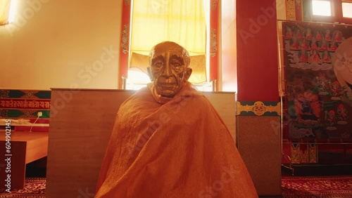Statue of the Dalai Lama in orange robes in Buddhist temple