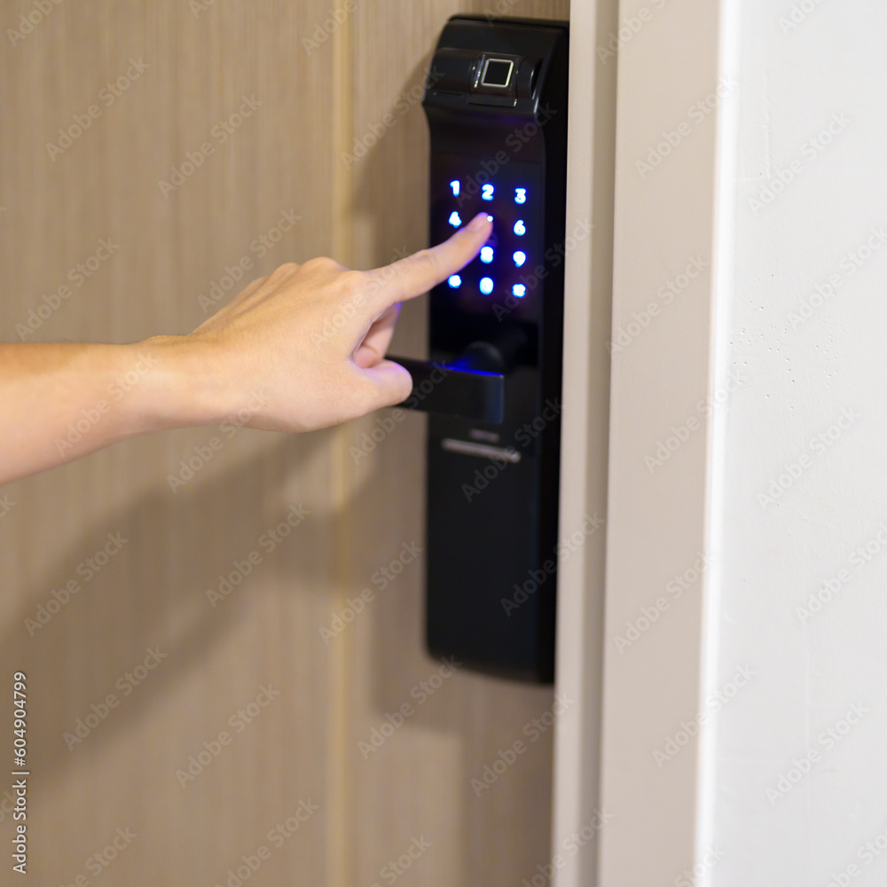 Hand press PIN number for smart digital door lock while open or close the door at home or apartment. NFC Technology, Fingerprint scan, keycard, smartphone and contactless lifestyle concepts Hand press PIN number for smart digital door lock while open or close the door at home or apartment. NFC Technology, Fingerprint scan, keycard, smartphone and contactless lifestyle concepts