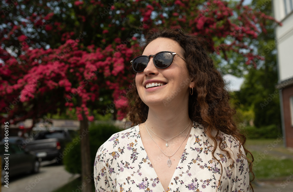 Portrait of a beautiful young woman with smile and sunglasses in the city. Portrait of a beautiful young woman with smile and sunglasses in the city.
