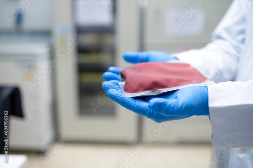 Doctor s hand holding blood bag in laboratory technician analyzing blood bag in blood bank