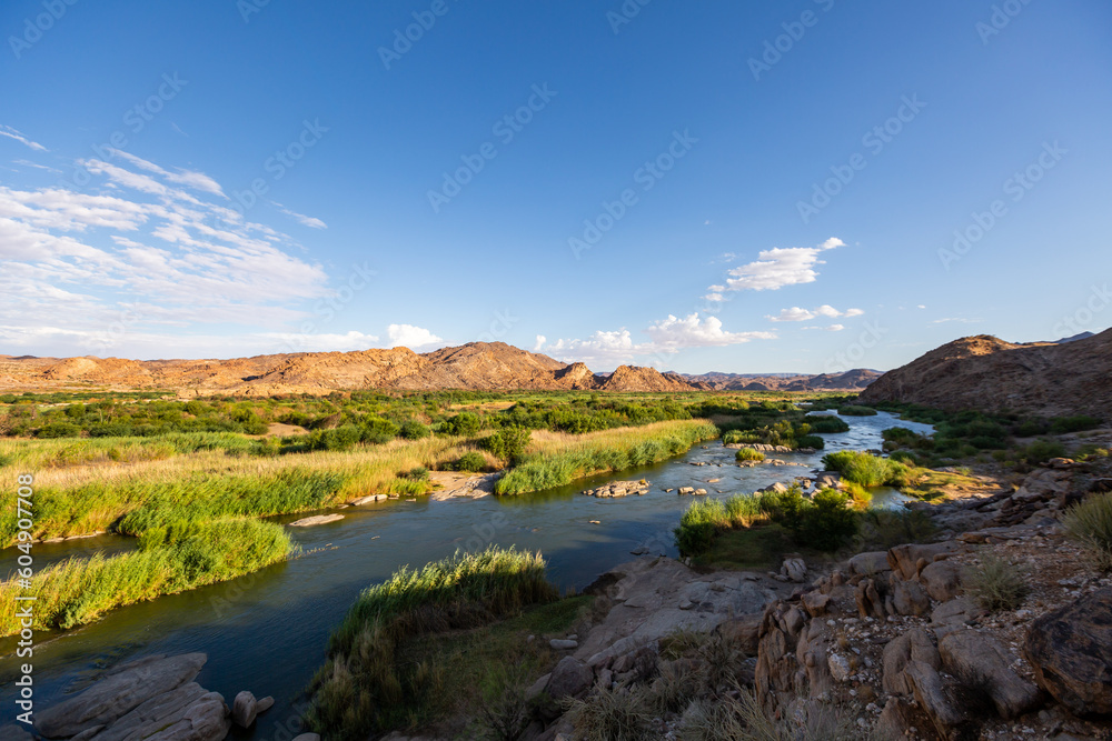 wide open landscape with a river and blue skies wide open landscape with a river and blue skies