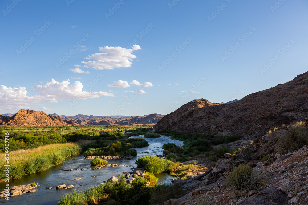 wide open landscape with a river and blue skies